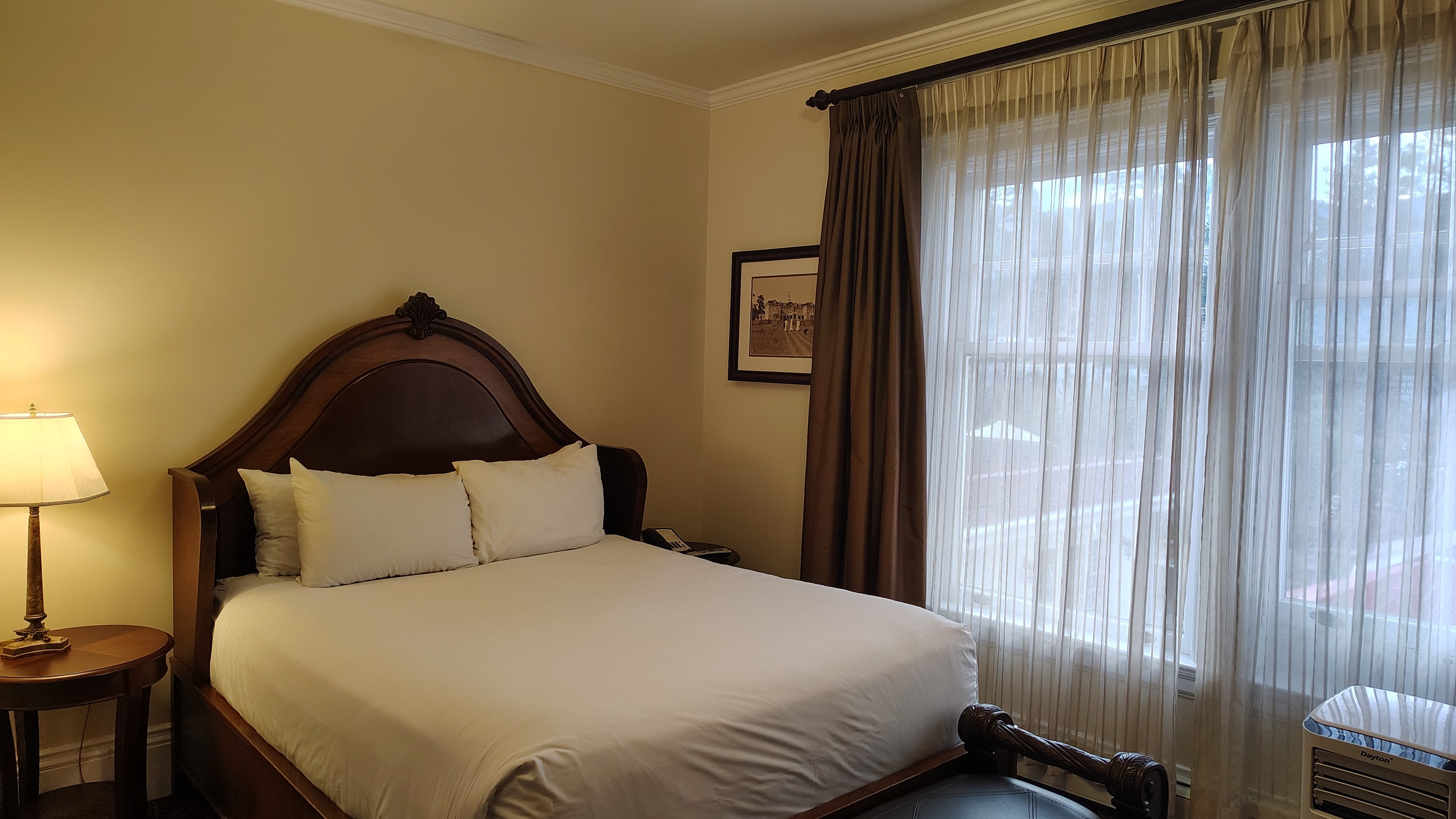 A queen-sized bed with a dark headboard in a room